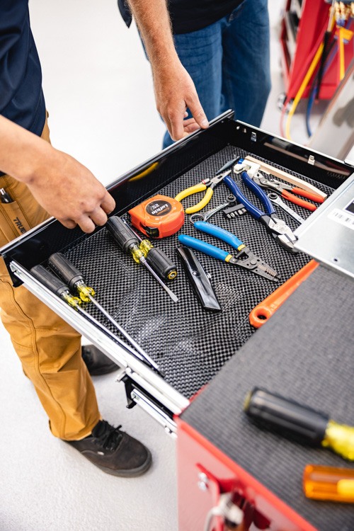 Technician opening drawer of rolling tool box